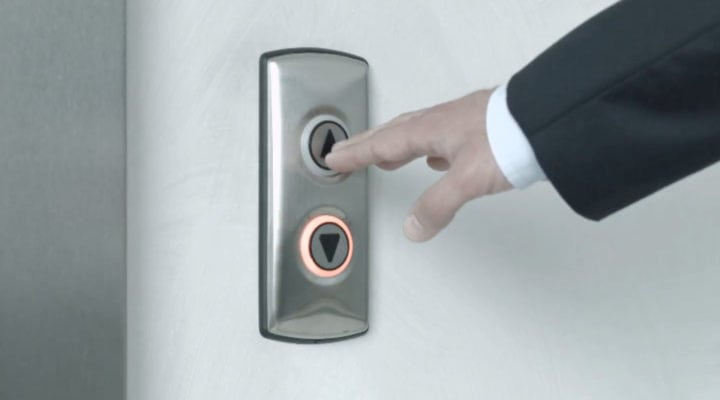 Hand pushing elevator buttons