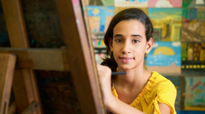 Teenage girl painting in an art classroom