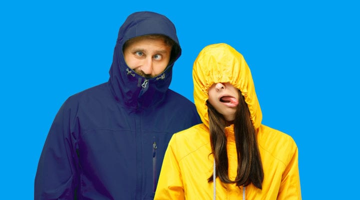 Man and woman wearing rain jackets making silly faces